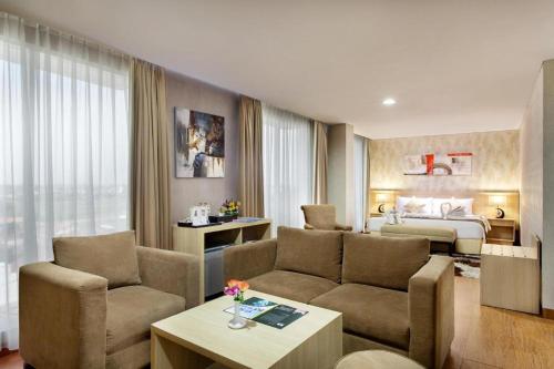 a hotel room with a bed and a living room at Days Hotel & Suites by Wyndham Jakarta Airport in Tangerang