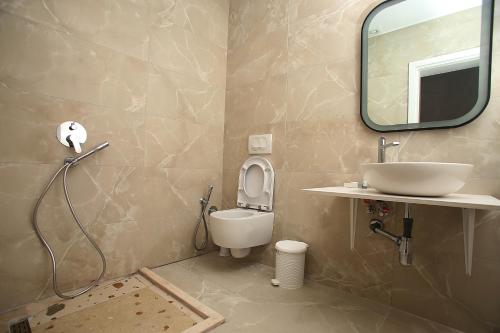 a bathroom with a sink and a toilet and a mirror at Diamond Hotel in Durrës
