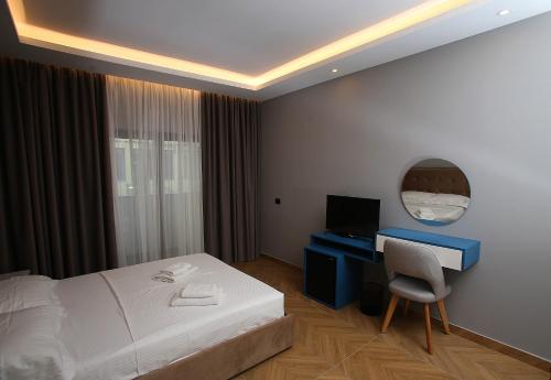 a hotel room with a bed and a desk with a computer at Diamond Hotel in Durrës