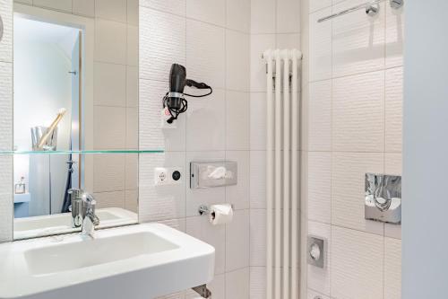 柏林的住宿－柏林檢查站查理精選酒店，白色的浴室设有水槽和淋浴。