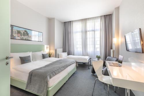 een hotelkamer met 2 bedden en een bureau bij Select Hotel Berlin Checkpoint Charlie in Berlijn