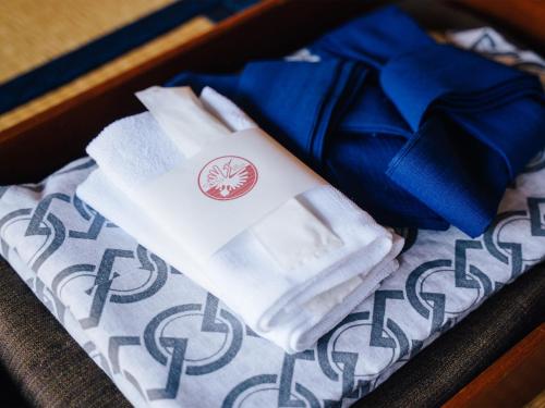 una caja con toallas blancas y una cinta azul en Oogute Kohan Shirasagi So en Shimojo mura