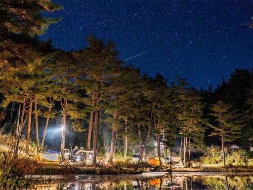 a night view of a campsite with a tent and trees at Oogute Kohan Shirasagi So in Shimojo mura