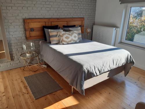 a large bed in a bedroom with a brick wall at Office des bons enfants in Huy