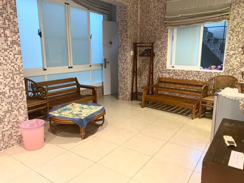 a room with benches and a table and windows at Er Jie's House in Tainan