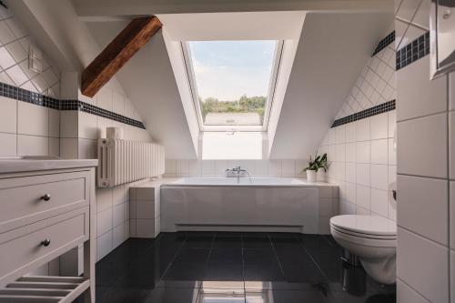 ein Bad mit einer weißen Badewanne und einem Fenster in der Unterkunft Die Sonne Nollingen in Nollingen