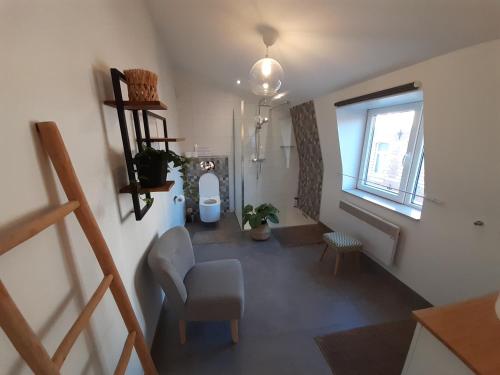 a living room with a chair and a window at Office des bons enfants in Huy