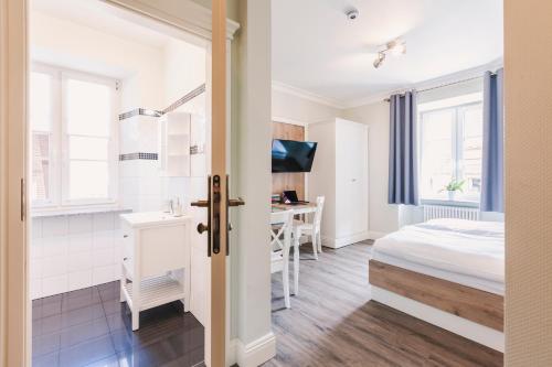 a bedroom with a bed and a desk in a room at Die Sonne Nollingen in Nollingen