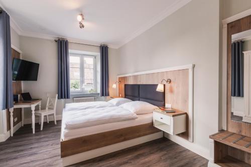 a bedroom with a large bed and a desk at Die Sonne Nollingen in Nollingen