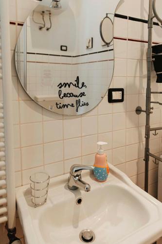 a bathroom sink with a mirror and a bottle on it at Il Loggione in Enna