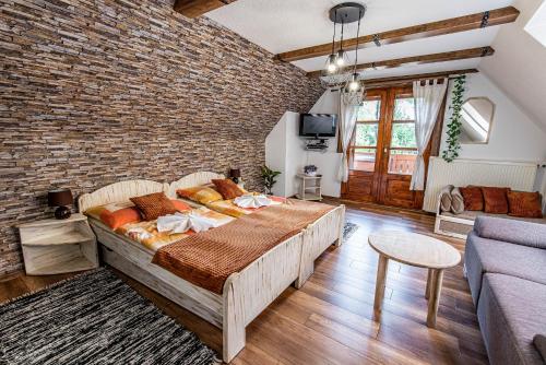 a bedroom with a large bed and a brick wall at Penzión Aurel in Liptovský Ján