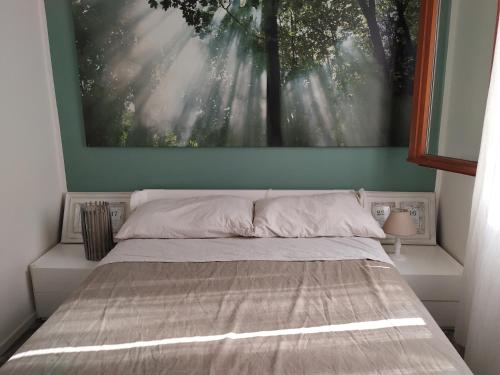 uma cama num quarto com um quadro na parede em Lovely lake wiev&pool em Malcesine