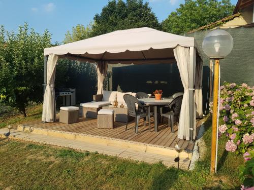 cenador con mesa y sillas en una terraza de madera en La Tana dei Sognatori - appartamenti con giardino, en Villanova dʼAsti