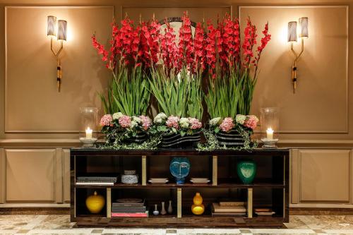 a large display of red flowers on a table at Flemings Mayfair - Small Luxury Hotel of the World in London