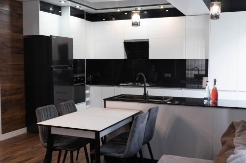 a kitchen with a table and chairs and a sink at RentWill apartments Modern in Chişinău