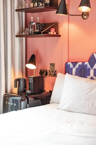 a bedroom with pink walls and a bed and a desk at The Dean Galway in Galway