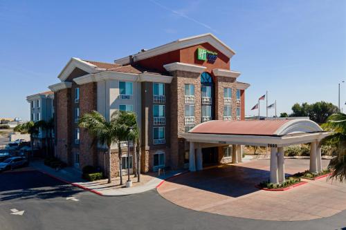a large brick building with a clock on the front at Holiday Inn Express Fresno South, an IHG Hotel in Fresno