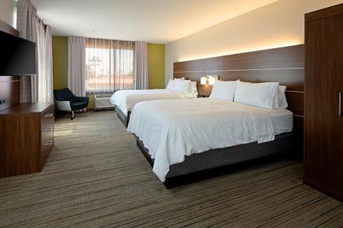 a hotel room with two beds and a television at Holiday Inn Express Fresno South, an IHG Hotel in Fresno