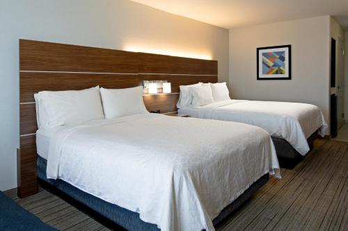 a hotel room with two beds with white sheets at Holiday Inn Express Fresno South by IHG in Fresno