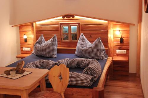 1 dormitorio con cama con almohadas y mesa en Familienbauernhof Christa, en Rossleithen