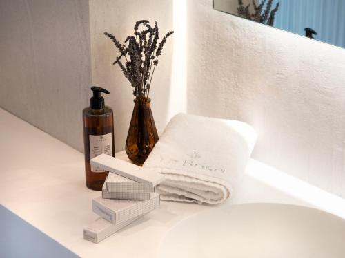 una barra de baño con toallas y una botella de jabón en La Brisa Boutique Hotel, en Dhërmi