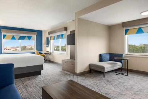 a hotel room with a bed and a chair at Holiday Inn Express Hotel & Suites Fort Pierce West by IHG in Fort Pierce