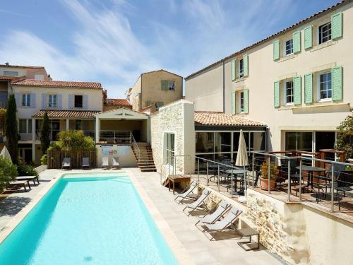 a swimming pool in front of a building with a house at Le Clos Du GALION - Ile de Ré in Saint-Martin-de-Ré