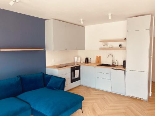 a living room with a couch and a kitchen at Apartament Family Premium - Baltic Sun Sztutowo in Sztutowo