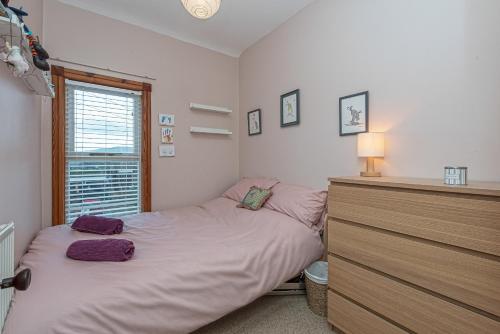 a bedroom with a bed with purple pillows on it at Beautiful Redbrick Home in Ruthin Centre & Parking in Ruthin