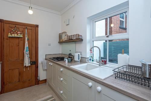 a kitchen with a sink and a window at Beautiful Redbrick Home in Ruthin Centre & Parking in Ruthin
