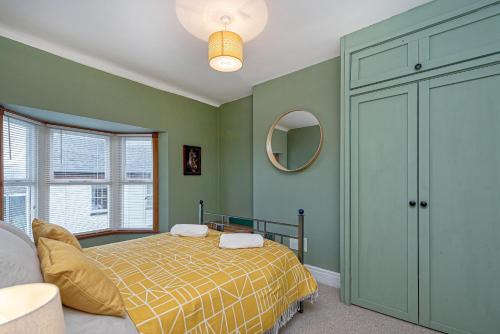 a bedroom with a bed and a mirror at Beautiful Redbrick Home in Ruthin Centre & Parking in Ruthin