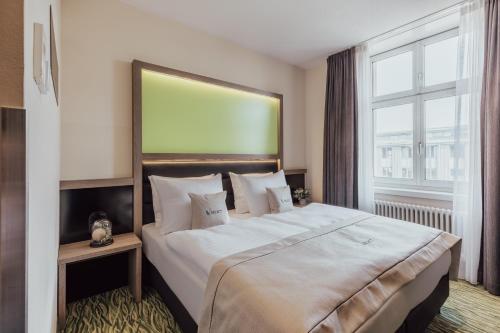 una camera da letto con un grande letto con una grande finestra di Select Hotel Style Berlin a Berlino