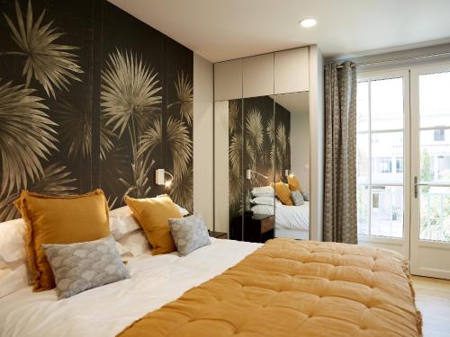 a bedroom with a large bed with yellow pillows at Hôtel Le Galion in Saint-Martin-de-Ré