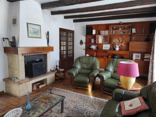 un salon avec deux chaises et une cheminée dans l'établissement Les Grands Prés, au Monêtier-les-Bains