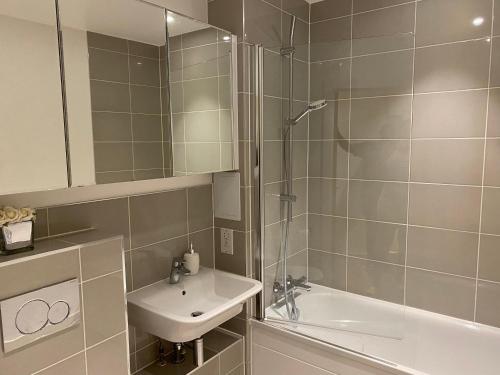 a bathroom with a shower and a sink and a tub at Triple t homes Cosy 2 bedroom Apartment with balcony in Ilford