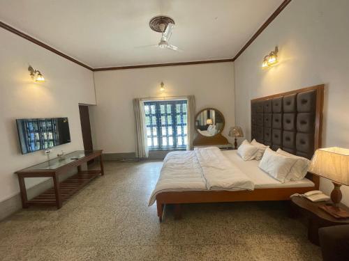 1 dormitorio con cama, lavabo y espejo en BNL FARMHOUSE, en Dhanbād