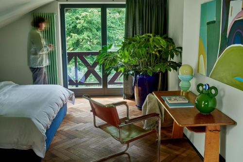 a bedroom with a bed and a table with a chair at FERN dom mazurski in Mrągowo