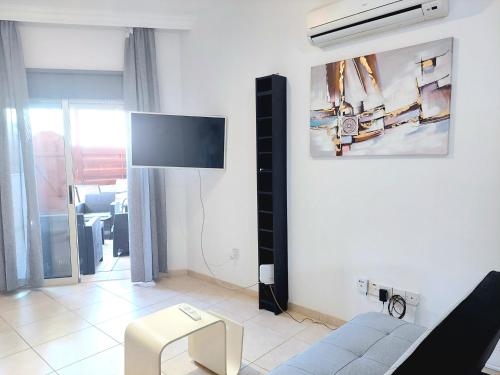 sala de estar con sofá y TV en la pared en Limassol Star 6, en Limassol