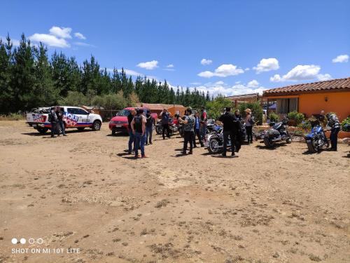 a group of people standing in a dirt lot with motorcycles at Willy's Country Club Cauquenes in De Cauquenes