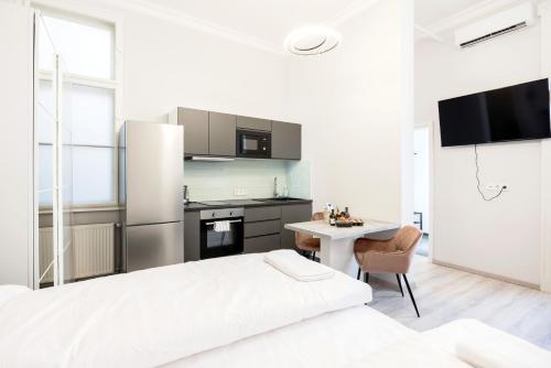 Dormitorio blanco con cama blanca y mesa en Prime Star Fashion street modern luxury apartments, en Budapest