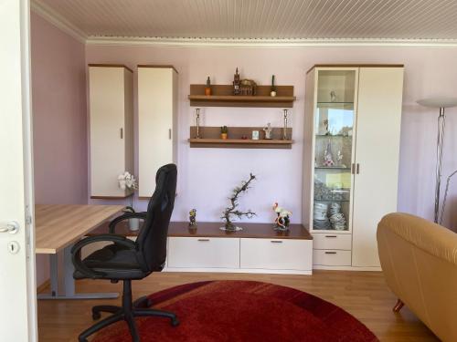 a office with a desk and a chair in a room at Ferienhaus direkt an der Luhe in Winsen