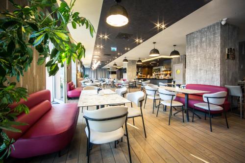 a restaurant with tables and chairs and a bar at Mercure Riga Centre in Rīga