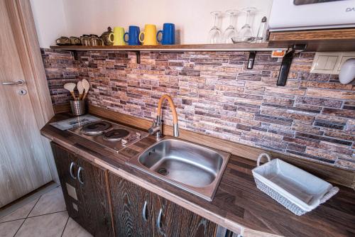a kitchen with a sink and a brick wall at Penzión Aurel in Liptovský Ján