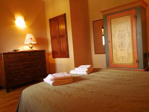 Un dormitorio con una cama y un tocador con toallas. en Residence il Poggiolino, en Montecarelli
