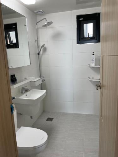 a white bathroom with a toilet and a sink at Lakestone&Hotel Sokcho in Sokcho