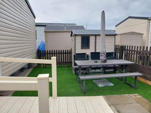a backyard with a picnic table and a surfboard at 95 Holiday Resort Unity 3 bed passes included in Brean