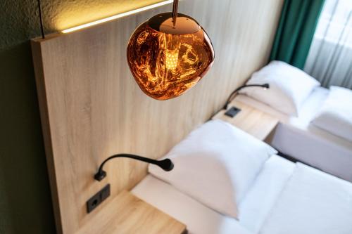 a light hanging from a wall with four beds at ACHAT Hotel Monheim am Rhein in Monheim