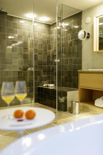 a bathroom with a tub and a glass shower at Hotel Aarnhoog in Keitum