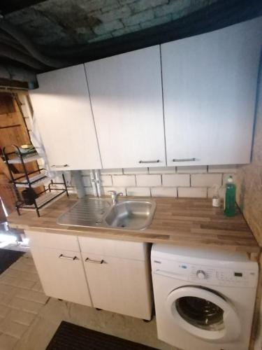a kitchen with a sink and a washing machine at Gemütliches Schlaffass am Schwimmteich mit Heizung in Burg