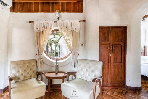 two chairs and a table in a room with a window at Naturetalk Homestay in Ban Don